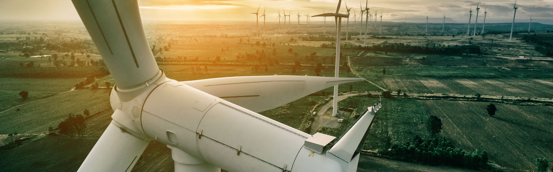 Stiff headwinds: Risk coverage for full maintenance for onshore wind turbines Front view of the hub and nacelle of a wind turbine, in the background the remaining wind turbines of the wind farm | Risk coverage for full maintenance for onshore wind turbines with NW Assekuranz